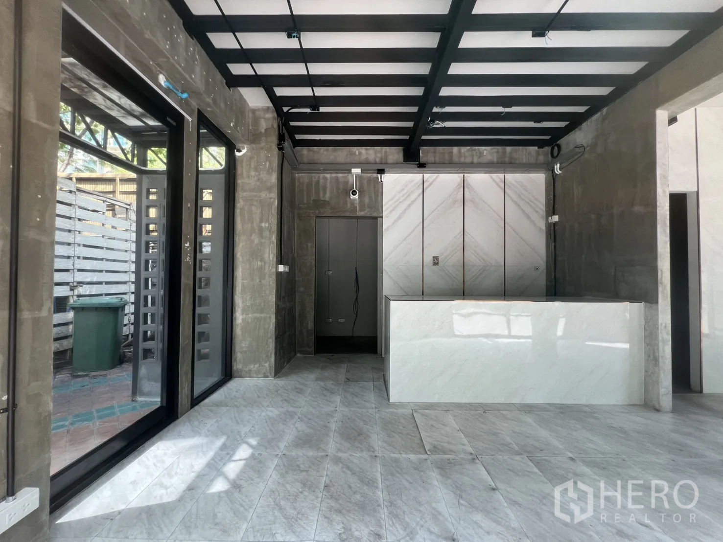 店屋 出租在Watthana, Bangkok - 入口区配玻璃门、大理石柜台与装饰墙面。