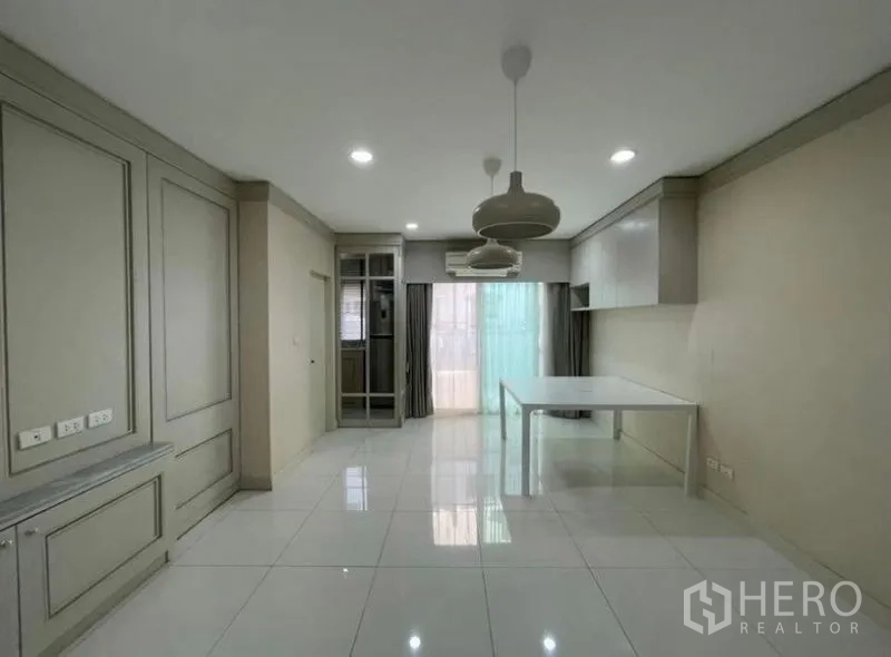 ทาวน์เฮาส์ ขาย - พื้นที่รับประทานอาหารแบบโอเพ่นแพลน โคมแขวน พื้นกระเบื้องสีขาวเงา และประตูกระจกบานเลื่อน
