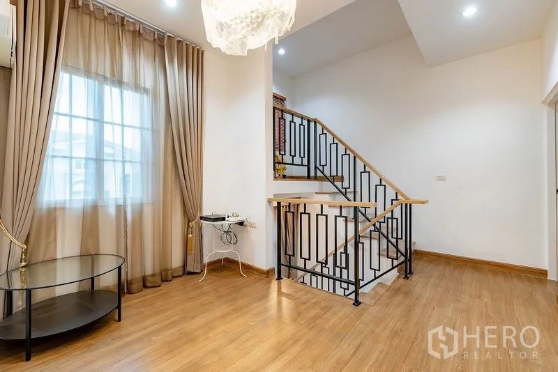 บ้าน ให้เช่าหรือขายในBang Khen, Bangkok - โถงชั้นบน ปูพื้นไม้ หน้าต่างบานใหญ่ และราวบันไดเหล็กสีดำ