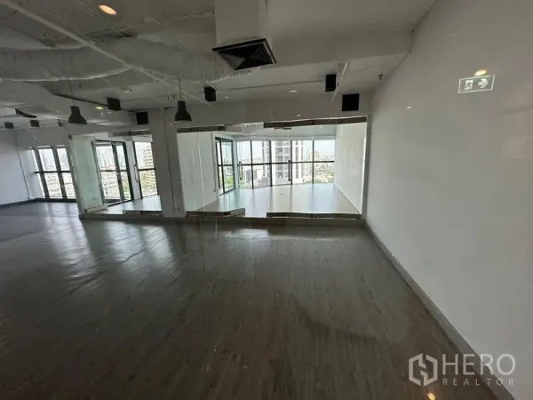 Office Space for rent - Spacious workspace with curved glass meeting room and floor-to-ceiling windows overlooking the city.