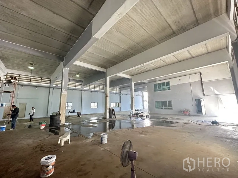 工厂 出租或出售在Bang Bua Thong, Nonthaburi - 宽大的厂房地面，高梁结构与采光，地面清洗区可见。