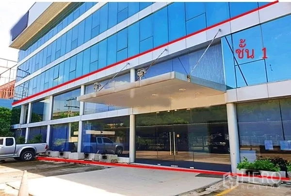 办公空间 出租在Suan Luang, Bangkok - 一层主入口，玻璃门、雨棚下客区与停车位。