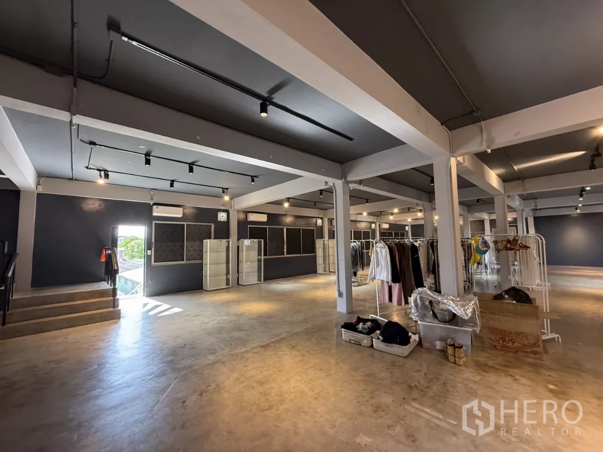Office Space for rent in Wang Thonglang, Bangkok - Large open workspace with clothing racks showing scale and lighting.