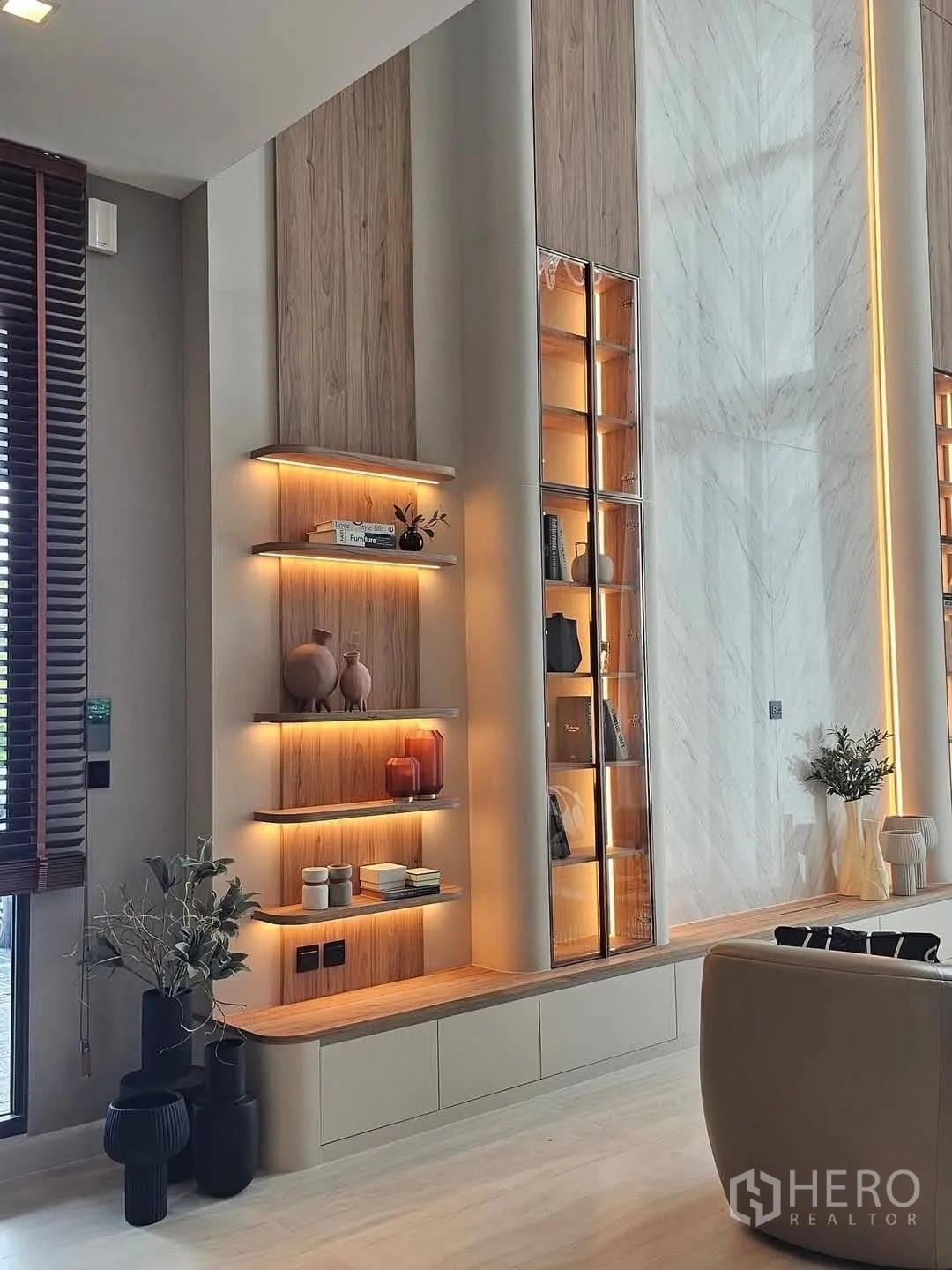 Detached House for rent or sale in Suan Luang, Bangkok - Living area feature wall with marble panel, lit shelves and glass cabinets.