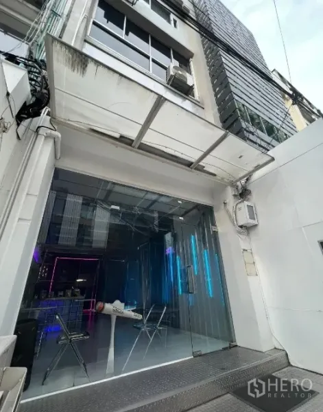 店屋 出租或出售在Watthana, Bangkok - 临街商铺入口，玻璃门面、雨棚与斜坡，靠近Phrom Phong站