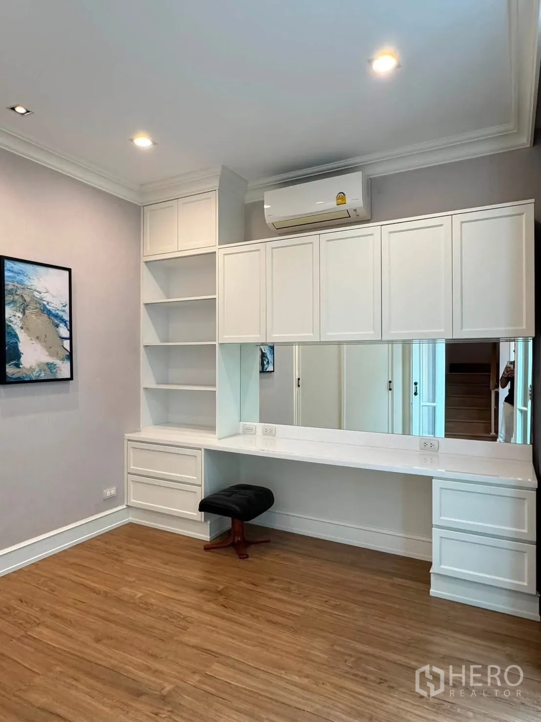 Townhouse for rent in Lat Phrao, Bangkok - Work desk area with upper cabinets, large mirror and stool.