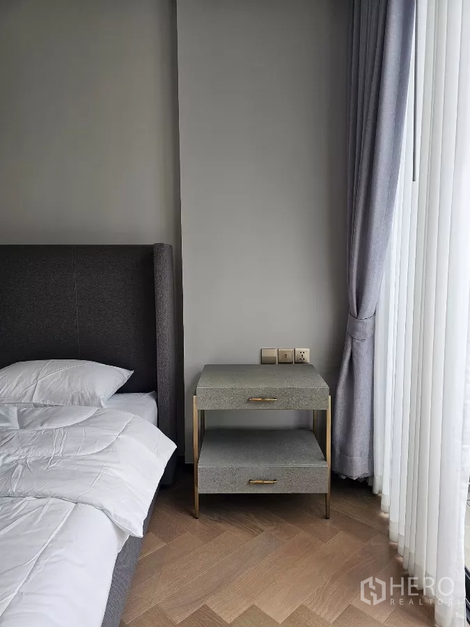 公寓 出租在Watthana, Bangkok - 床侧柜与全高窗帘，靠软包床头。