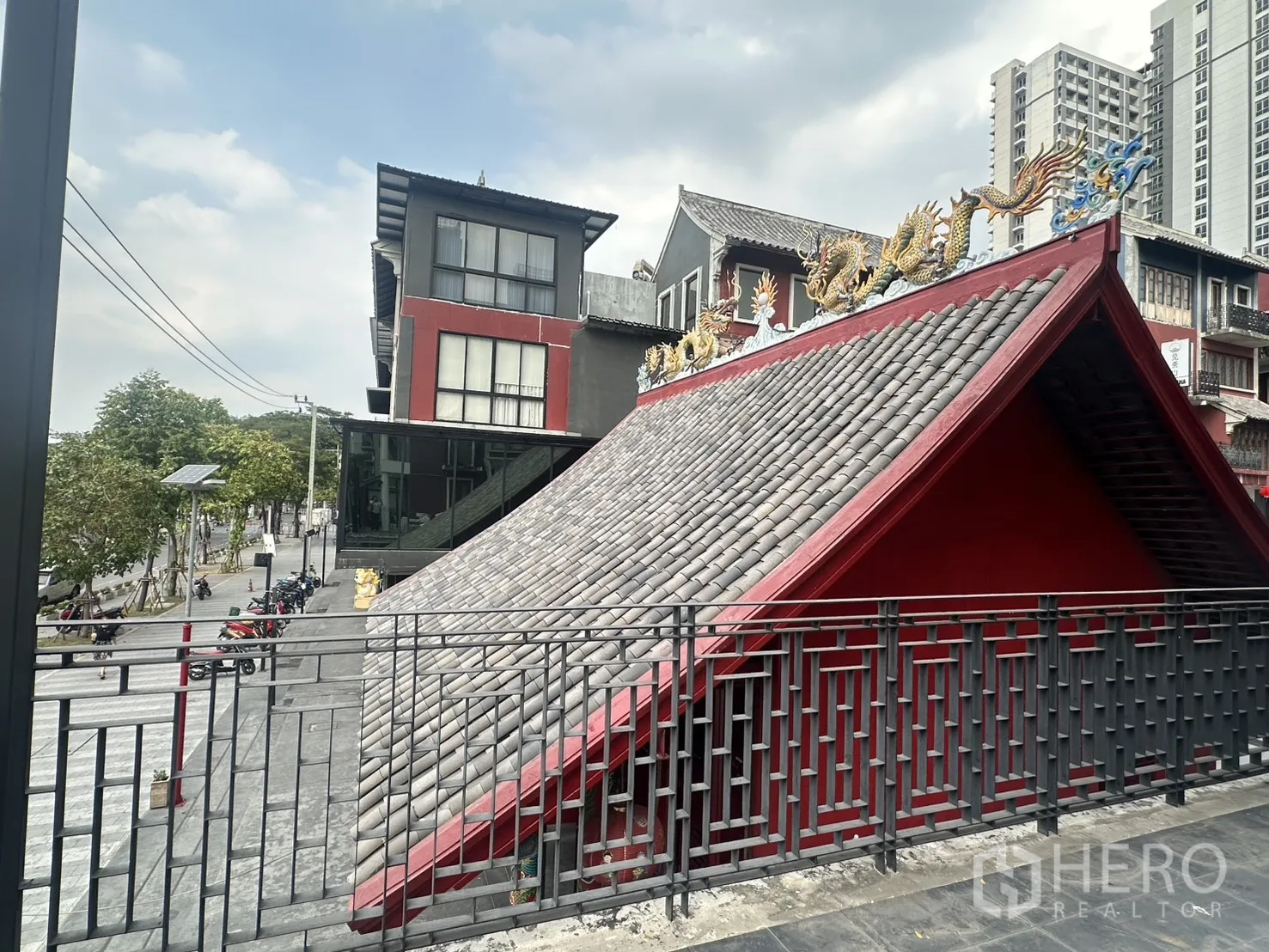 带办公室的家 for rent in Pathum Wan, Bangkok - 阳台俯看灰瓦人字顶及龙形装饰，旁有低层建筑。