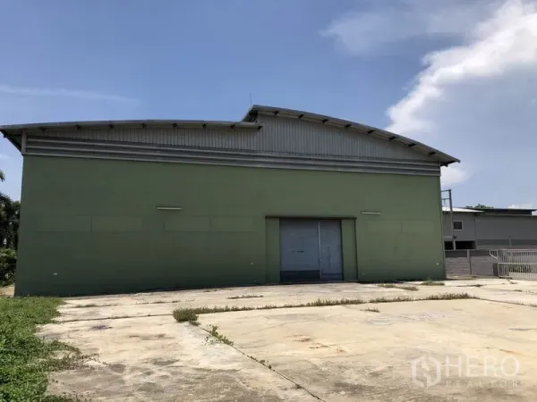 工厂 出租在Pathum Thani - 工厂侧立面，配大卷闸门与宽阔混凝土前场