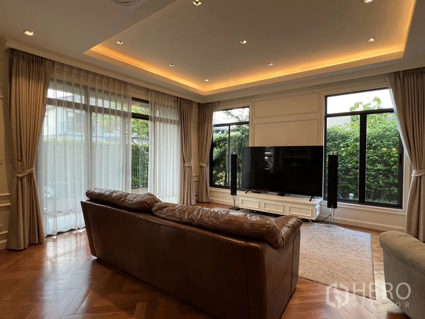 Detached House for rent in Suan Luang, Bangkok - Living room with floor-to-ceiling curtains and cove lighting.