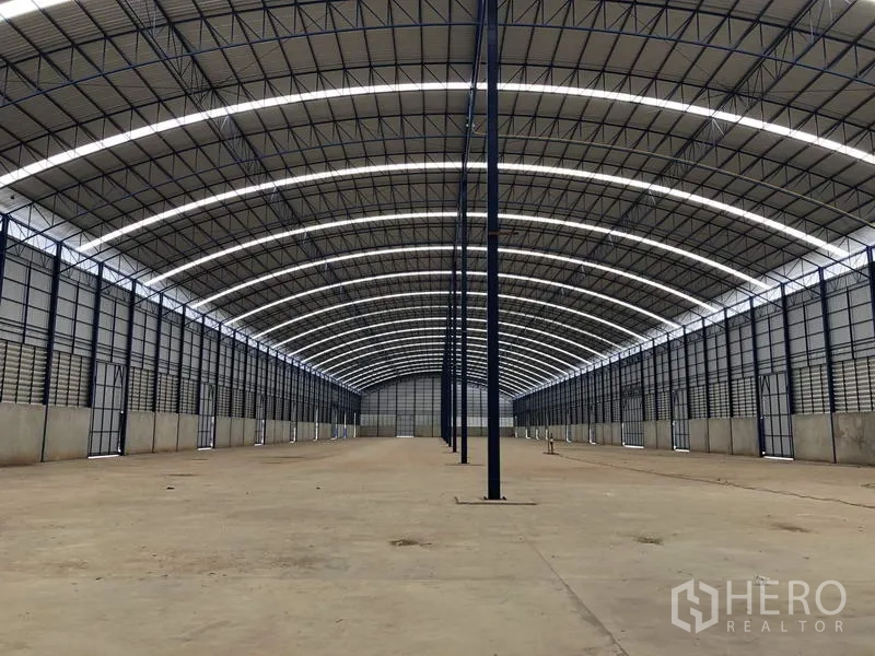 Factory for rent or sale in Lat Lum Kaeo, Pathum Thani - Central view down the aisle showing wide column spacing and smooth concrete floor.
