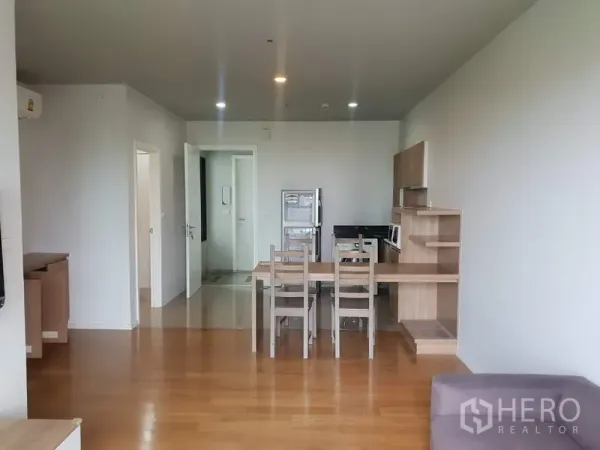 公寓 出租在Watthana, Bangkok - 餐桌与紧凑厨房，木质橱柜和家电