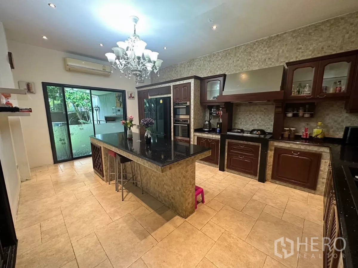 บ้าน ให้เช่าหรือขายในBang Kapi, Bangkok - มุมมองอีกด้านของครัว เตาอบคู่ ฮู้ดดูดควัน และทางออกลานหลังบ้าน