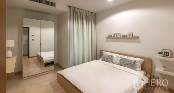 公寓 出租或出售在Watthana, Bangkok - 明亮卧室，配有大床、镜面衣柜、置物架装饰与浅色木地板。