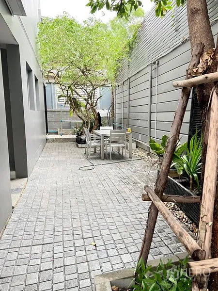 Townhouse for rent in Saphan Sung, Bangkok - Private side patio with paver walkway, outdoor table, plants and a shade tree.