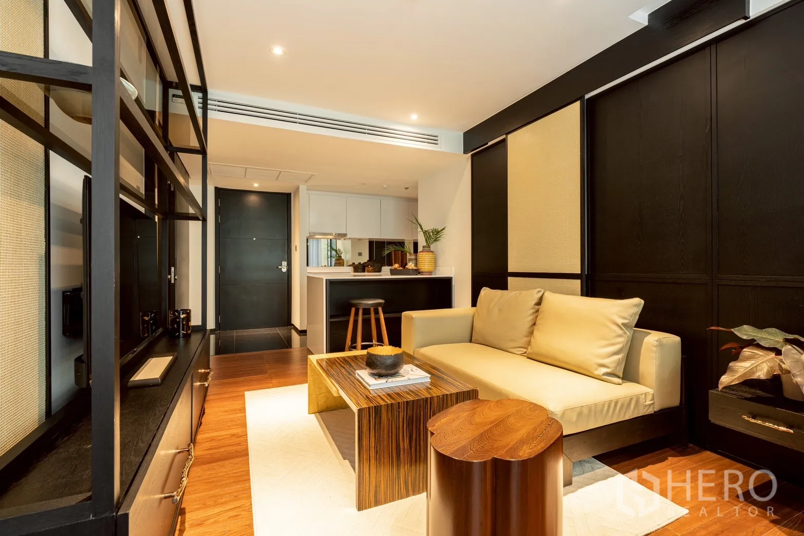 公寓 for rent or sale in Pathum Wan, Bangkok - 客厅面对开放式厨房与金属框电视墙。