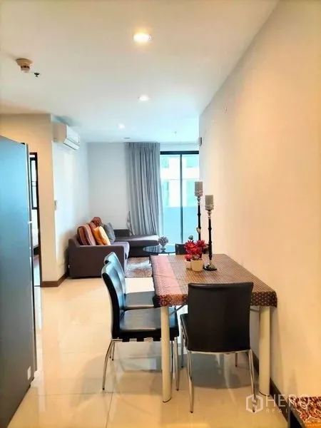 คอนโด ให้เช่าในWatthana, Bangkok - พื้นที่รับประทานอาหารเชื่อมต่อห้องนั่งเล่น พร้อมประตูกระจกออกสู่ระเบียงในคอนโดสมัยใหม่