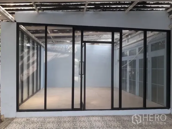 บ้าน ให้เช่าในWatthana, Bangkok - ห้องกระจกกรอบอลูมิเนียมสีดำพร้อมประตูบานเลื่อนและลานกระเบื้อง