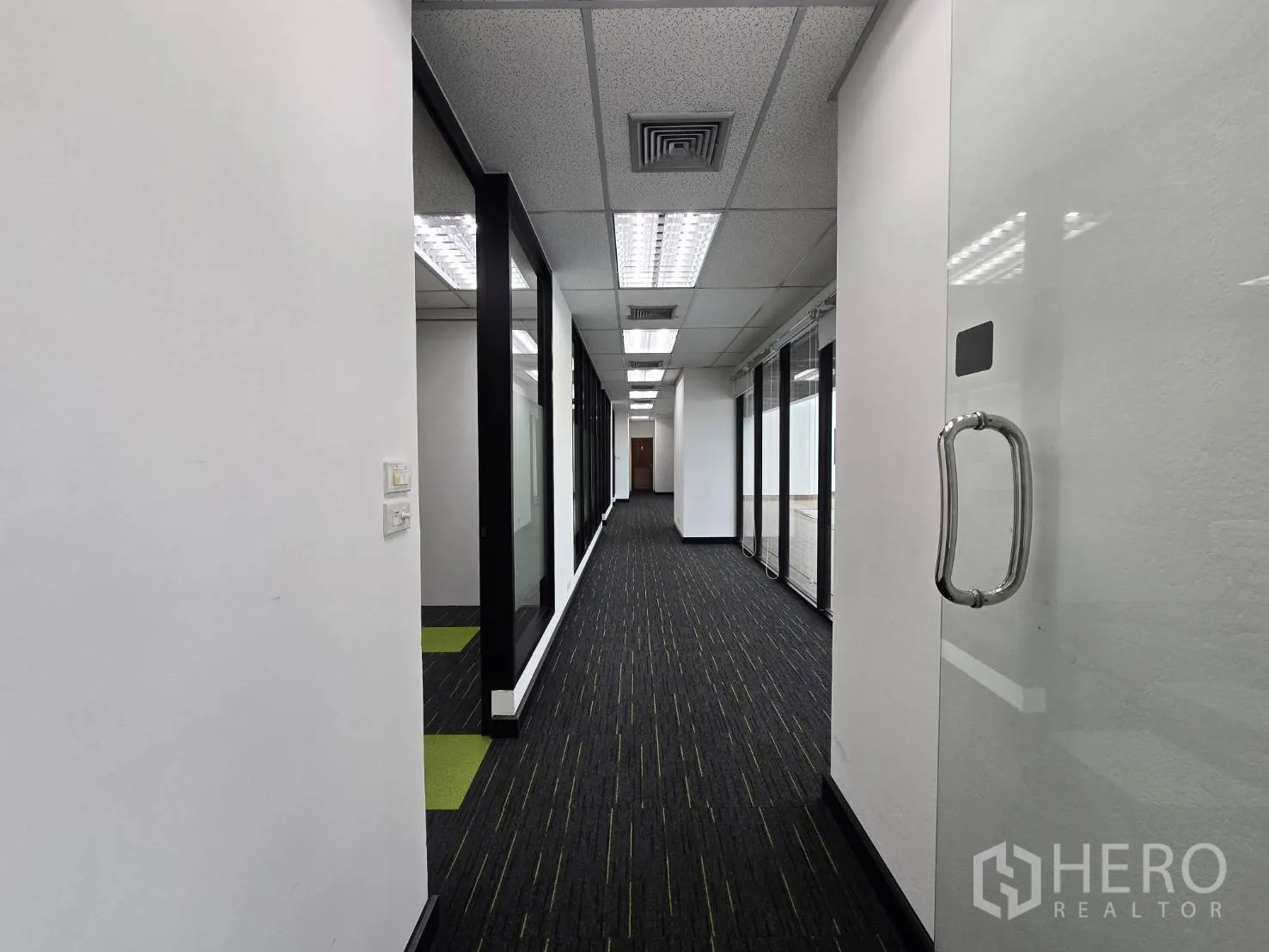 Office Space for rent in Watthana, Bangkok - Long office corridor with glass partitions, white walls, and fluorescent lighting.
