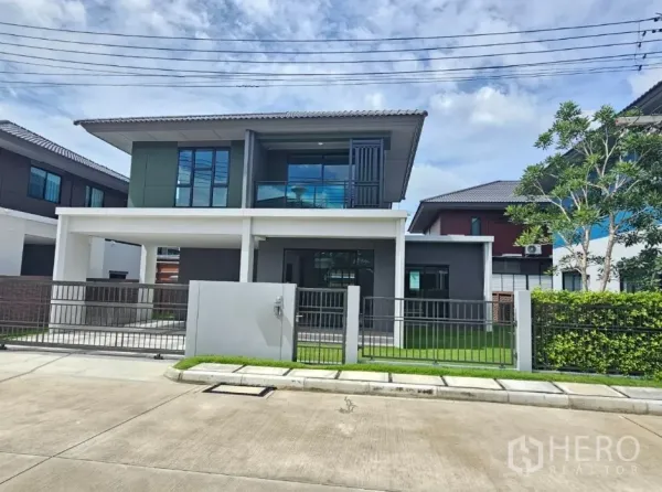 บ้าน ขายในLam Luk Ka, Pathum Thani - ด้านหน้าบ้านพร้อมระเบียง รั้ว และสนามหญ้าสีเขียว