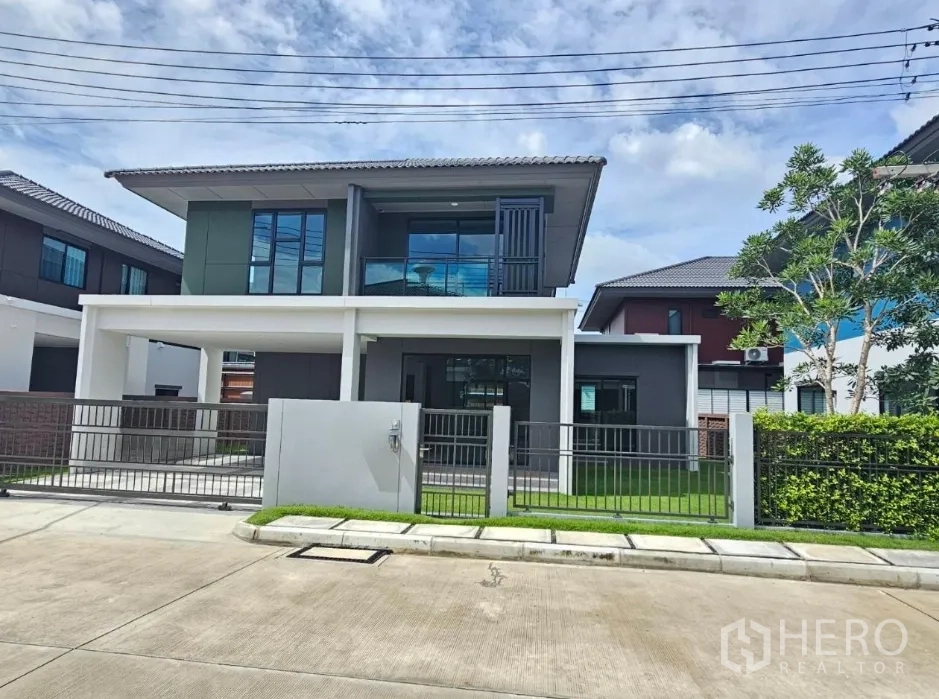 บ้าน ขายในLam Luk Ka, Pathum Thani - ด้านหน้าบ้านพร้อมระเบียง รั้ว และสนามหญ้าสีเขียว