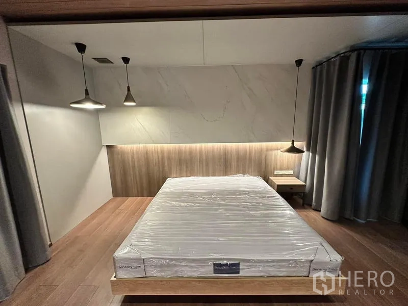 Detached House for rent in Bang Phli, Samut Prakan - Master bedroom featuring a sleek headboard wall, pendant lights, large bed and blackout curtains.