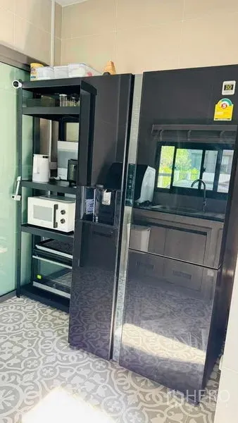 Detached House for rent in Bang Khun Thian, Bangkok - Enclosed kitchen with large black side-by-side refrigerator, shelving and patterned floor tiles.