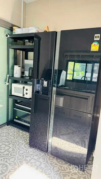 Detached House for rent in Bang Khun Thian, Bangkok - Enclosed kitchen with large black side-by-side refrigerator, shelving and patterned floor tiles.