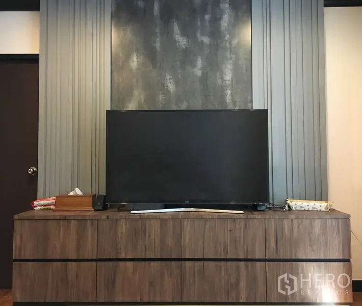 公寓 出售在Khlong Toei, Bangkok - 近景电视与木质电视柜，背景为现代质感墙面。