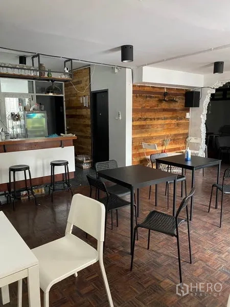 สำนักงานที่บ้าน ให้เช่าในPathum Wan, Bangkok - ชั้นล่างมีผนังลายไม้ โต๊ะสีดำ และเคาน์เตอร์บาร์ขนาดกะทัดรัด