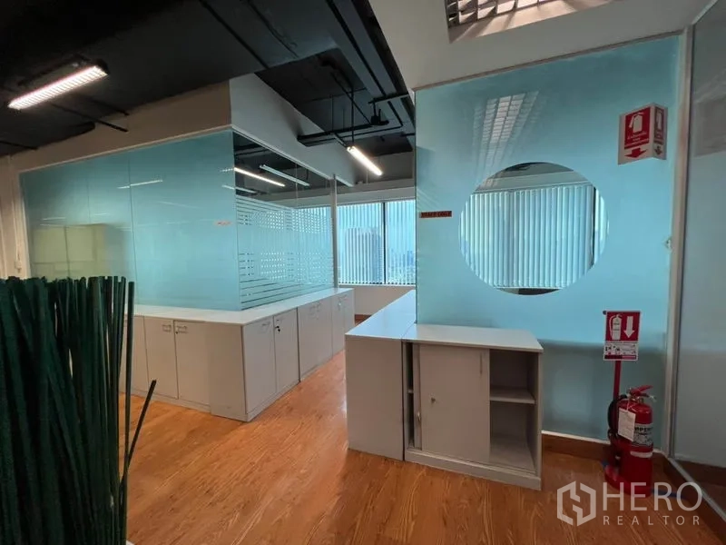 Office Space for rent in Khlong Toei, Bangkok - Frosted glass partitions with built-in storage cabinets and visible fire safety equipment.