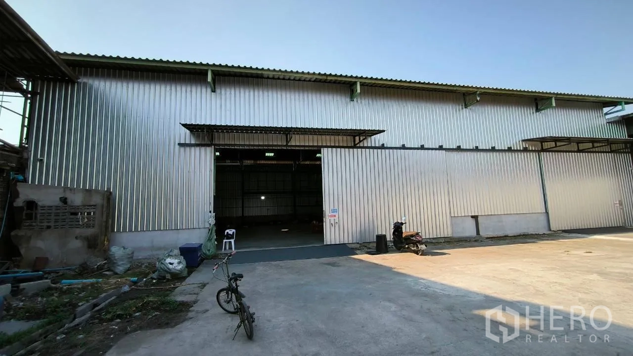 Factory for rent in Mueang Samut Prakan, Samut Prakan - Metal-clad building facade with high sliding entry and forecourt.