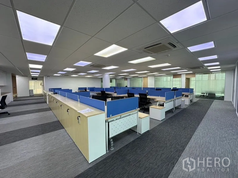 办公空间 出租 - 开放式办公区，蓝色隔断工位与明亮LED灯。