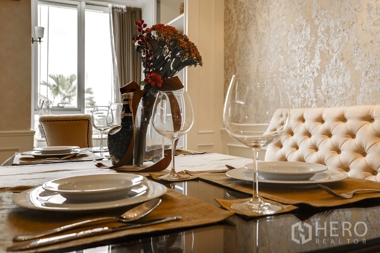 คอนโด ให้เช่าหรือขายในWatthana, Bangkok - โต๊ะรับประทานอาหารจัดเซตอย่างหรู พร้อมเบาะพนักพิงกระดุมและแจกันดอกไม้ ใกล้หน้าต่างรับแสง