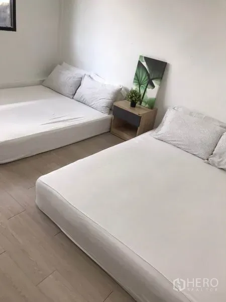 带办公室的家 出租 - 宽敞卧室，两张低床与床头柜，装饰简洁。