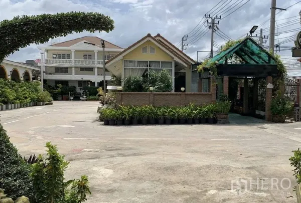 Warehouse for rent in Phra Pradaeng, Samut Prakan - Gated entrance and landscaped courtyard with small pavilion and plants at an industrial compound.