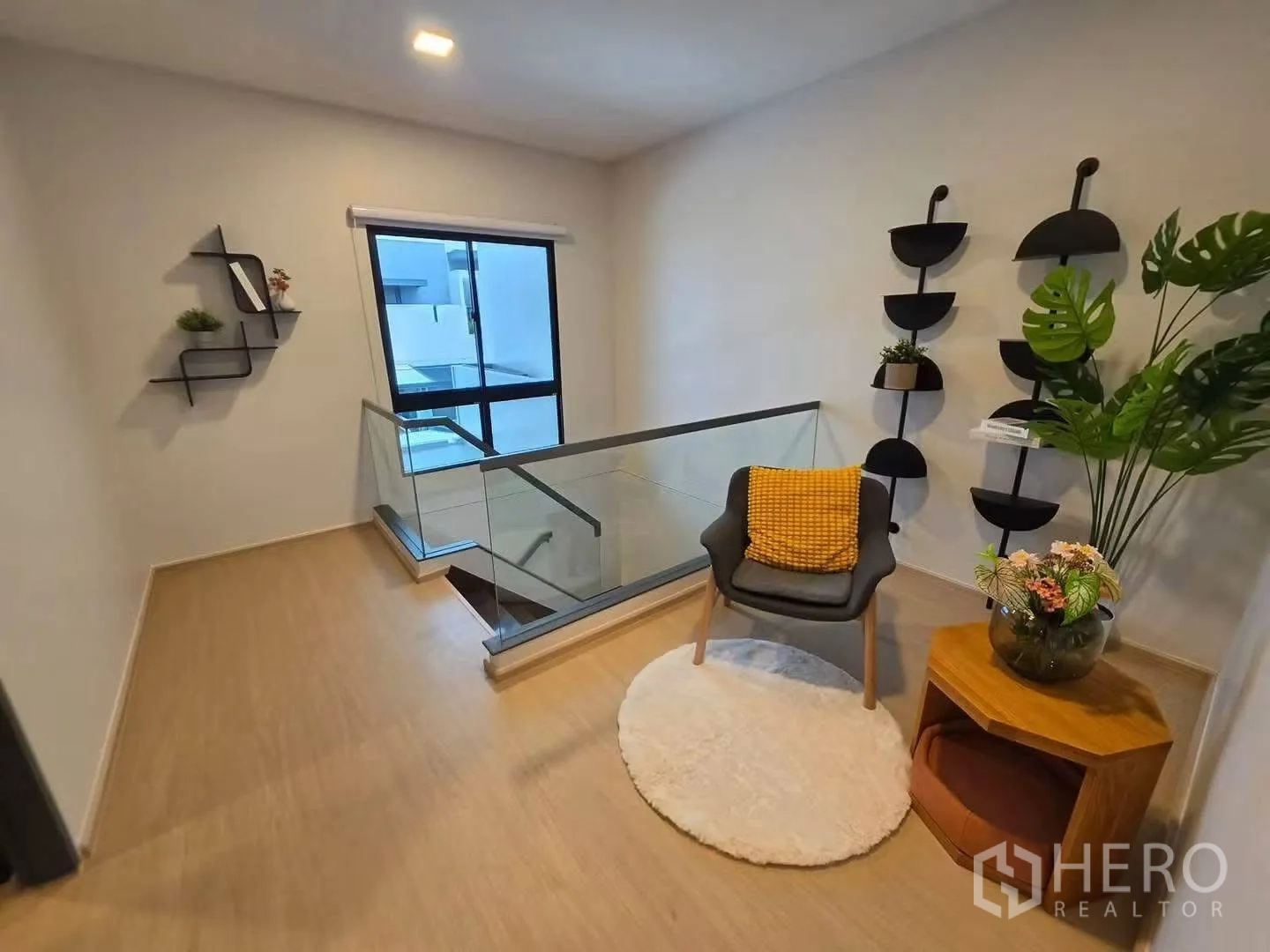 ทาวน์เฮาส์ for rent in Bang Phli, Samut Prakan - โถงบันไดชั้นบนมีเก้าอี้มุมนั่งพักผ่อน โต๊ะข้าง และราวกันตกกระจก