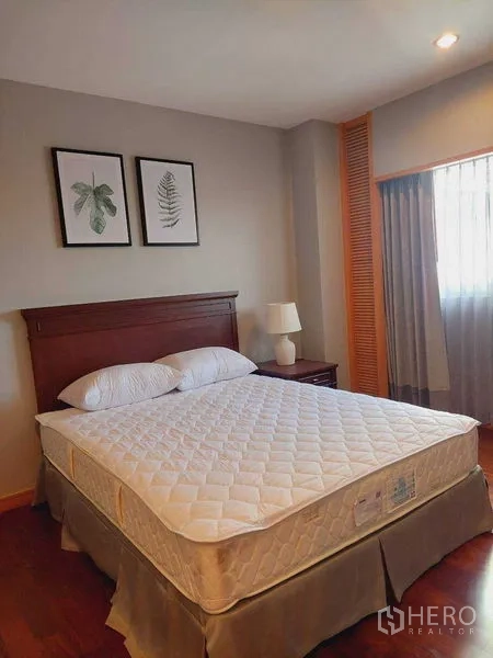 房间 出租 - 明亮卧室，木质床头、床头灯、植物装饰画与木地板。