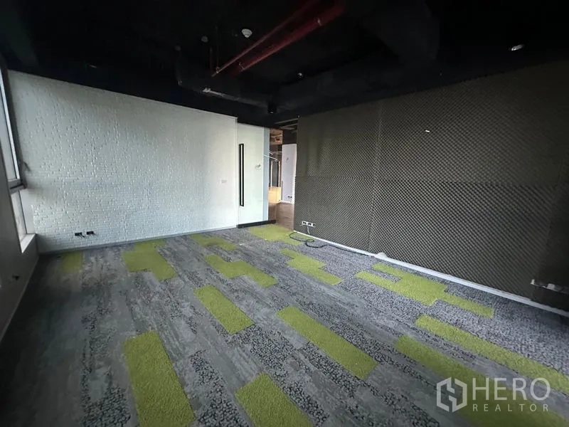 Office Space for rent in Bang Rak, Bangkok - Meeting room with acoustic walls, patterned carpet, and dark exposed ceiling.