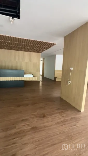 零售空间 出租在Bang Na, Bangkok - 接待区，木格栅天花与内置前台，地面为木色地板。