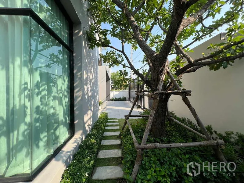 Detached House for sale in Suan Luang, Bangkok - Side garden path with mature tree, stepping stones and low hedges