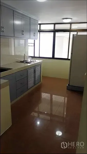 公寓 出租或出售在Khlong Toei, Bangkok - 独立厨房，灰色柜体，灶台、水槽、冰箱与大窗户采光。