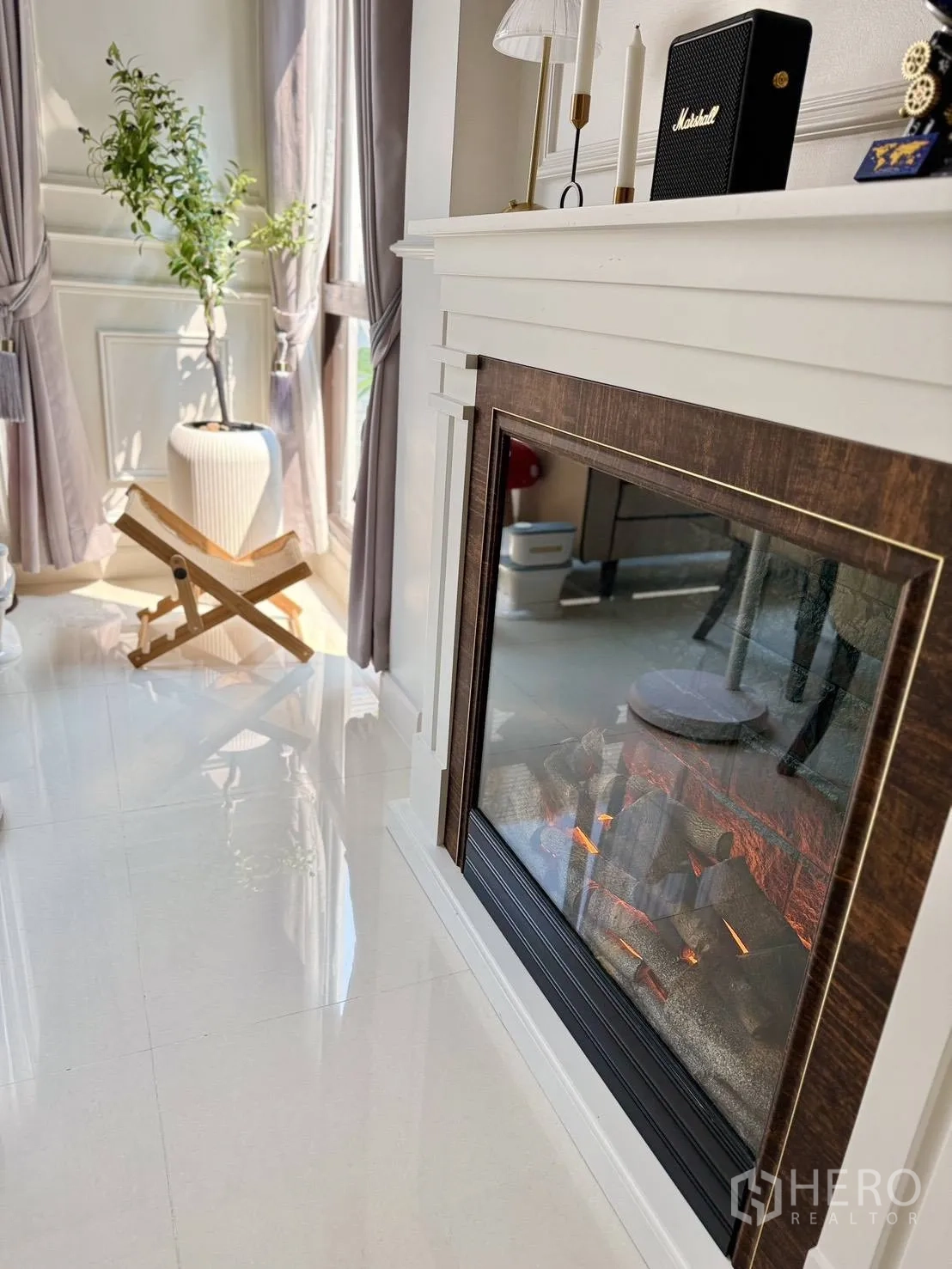 Detached House for rent in Wang Thonglang, Bangkok - Decorative electric fireplace beside tall windows and a floor vase.