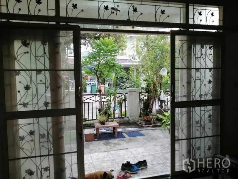 บ้าน ขายในPrawet, Bangkok - ประตูกระจกบานเลื่อนติดเหล็กดัดลายดอกไม้ มองออกไปยังเฉลียงและสวนหน้า