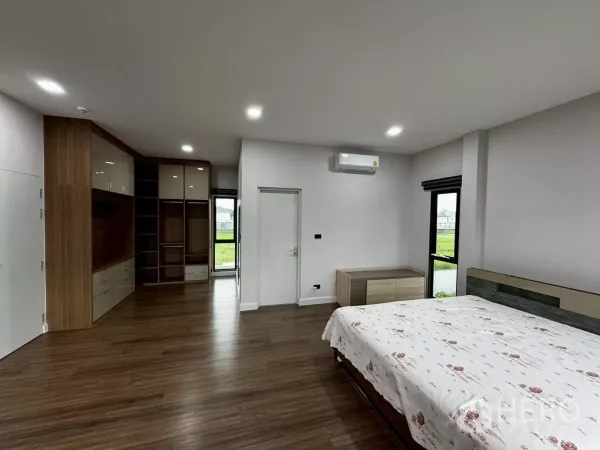 บ้าน ให้เช่าหรือขายในLat Krabang, Bangkok - ห้องนอนพร้อมตู้เสื้อผ้าบิวท์อิน พื้นไม้ และเครื่องปรับอากาศติดผนัง.