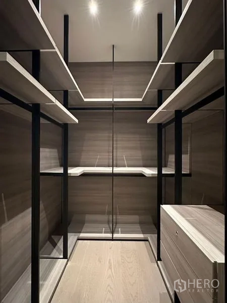 Condominium for rent or sale - Walk-in closet with glass-front cabinets and adjustable shelving.