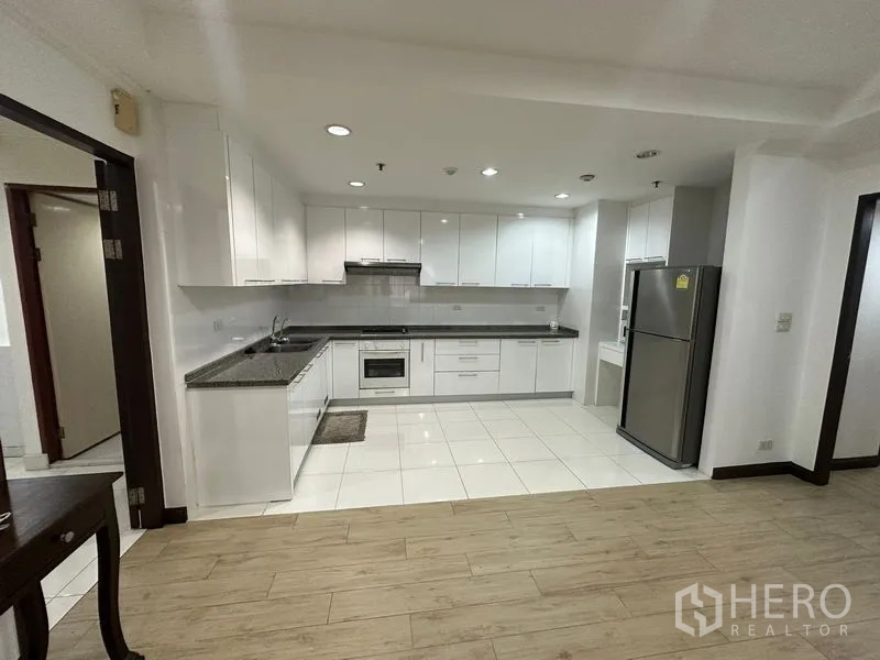คอนโด ให้เช่าในWatthana, Bangkok - ครัวเปิดโทนขาว ตู้บิวท์อิน เคาน์เตอร์หินแกรนิต เตาอบ และตู้เย็นขนาดใหญ่