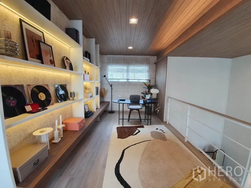Detached House for rent in Prawet, Bangkok - Loft-style home office with illuminated shelving, desk and wood ceiling.
