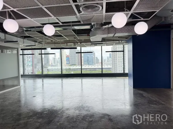 办公空间 出租在Din Daeng, Bangkok - 大开间配球形灯与整面窗，框出曼谷景观。