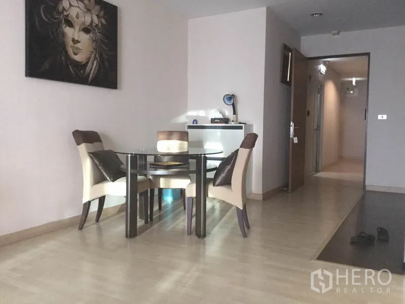 公寓 出租在Watthana, Bangkok - 温馨用餐角，玻璃餐桌配四椅，临走廊与入户门，内置柜体配中性配色。